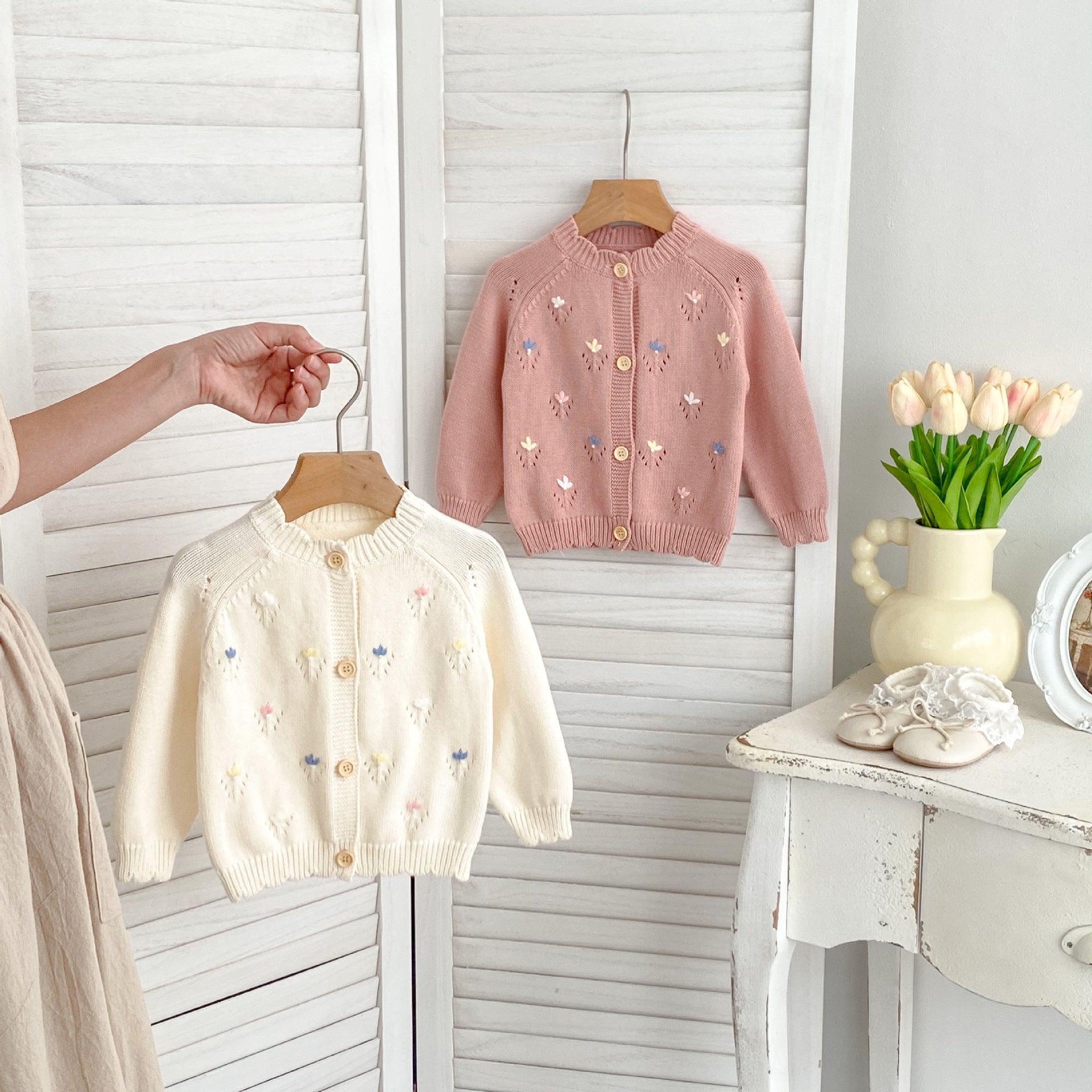 A pink and beige knitted long for baby girls featuring floral embroidery, perfect for all seasons.