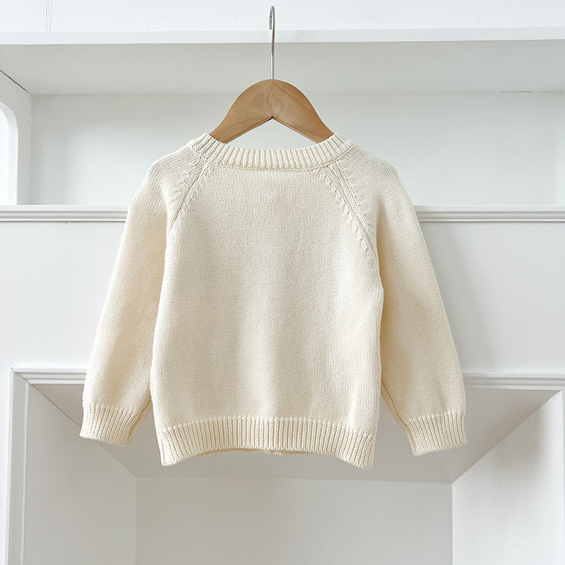 A baby girl wearing a comfortable cotton outfit with embroidered flowers and pockets, perfect for various seasons.