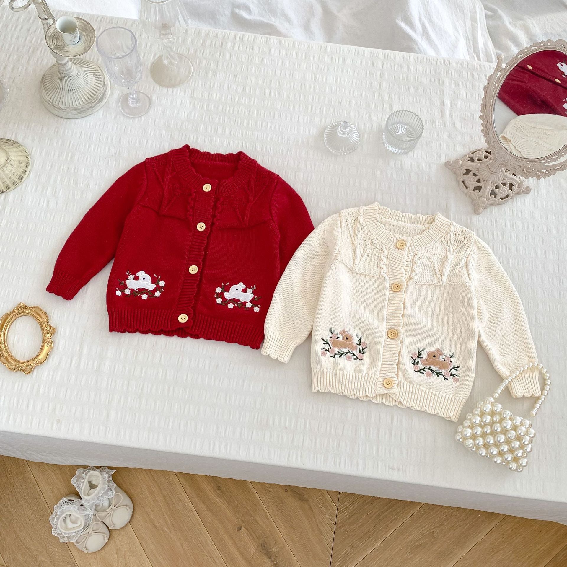 A cozy knitted long outfit for baby girls featuring cute rabbit embroidery, available in red and beige colors.