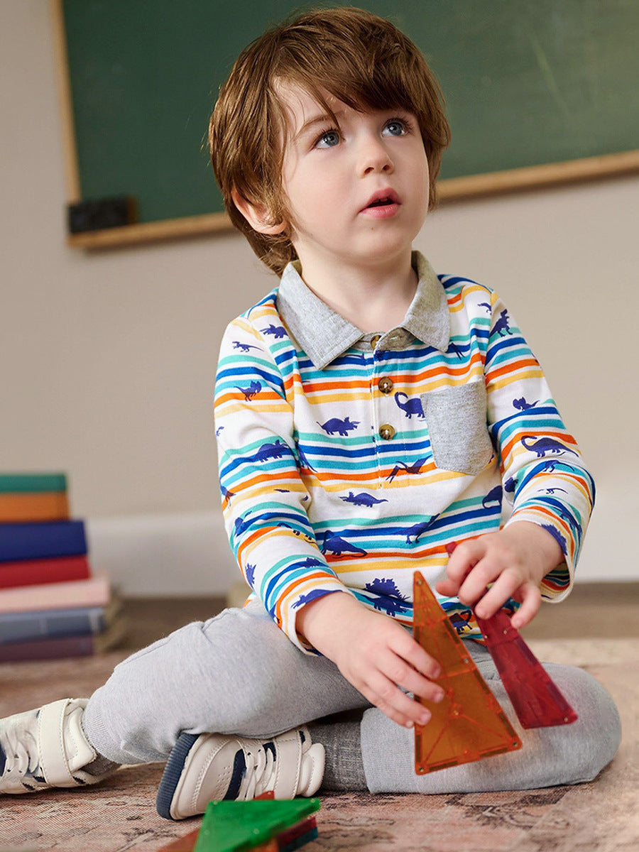 A grey long-sleeve shirt featuring a playful dinosaur print and striped pattern, perfect for boys aged 12 months to 10 years.