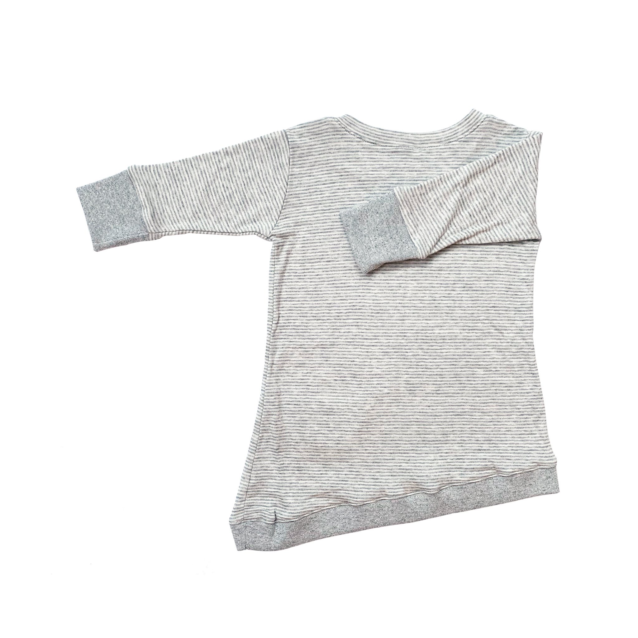 Asymmetric dress for toddlers featuring grey skinny stripes, thumbholes, and a peek-a-boo front pocket.