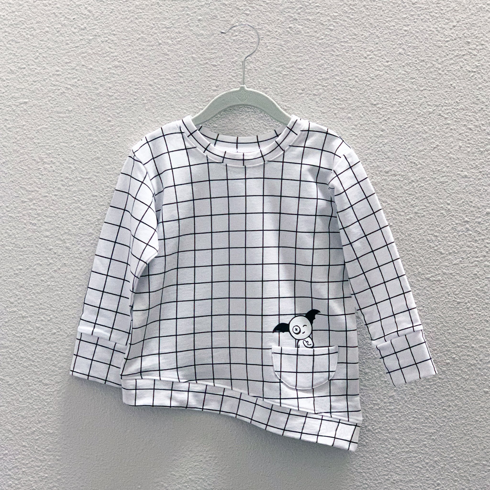 Asymmetric Pullover in Black and White Grid with a monster peek-a-boo pocket and thumbholes for toddlers.