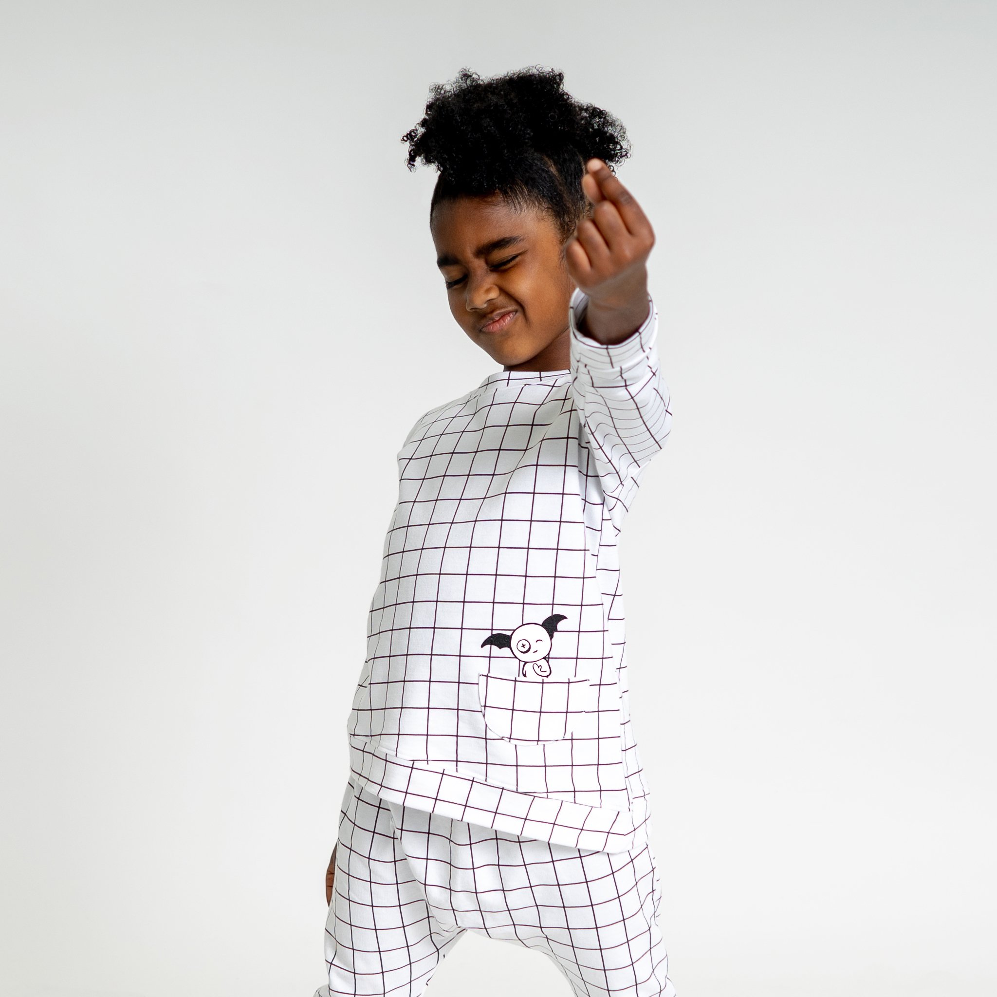 Asymmetric Pullover in Black and White Grid with a monster peek-a-boo pocket and thumbholes for toddlers.