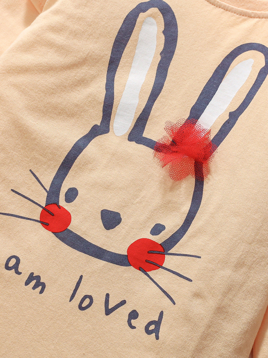 A cute long-sleeved t-shirt for girls featuring a rabbit cartoon pattern, made from soft cotton in apricot color.