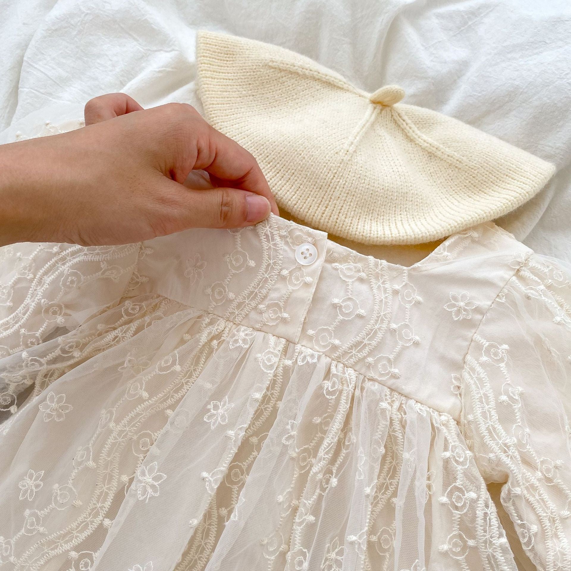 A stylish apricot onesies dress for baby girls featuring a mesh patched design, perfect for autumn wear.