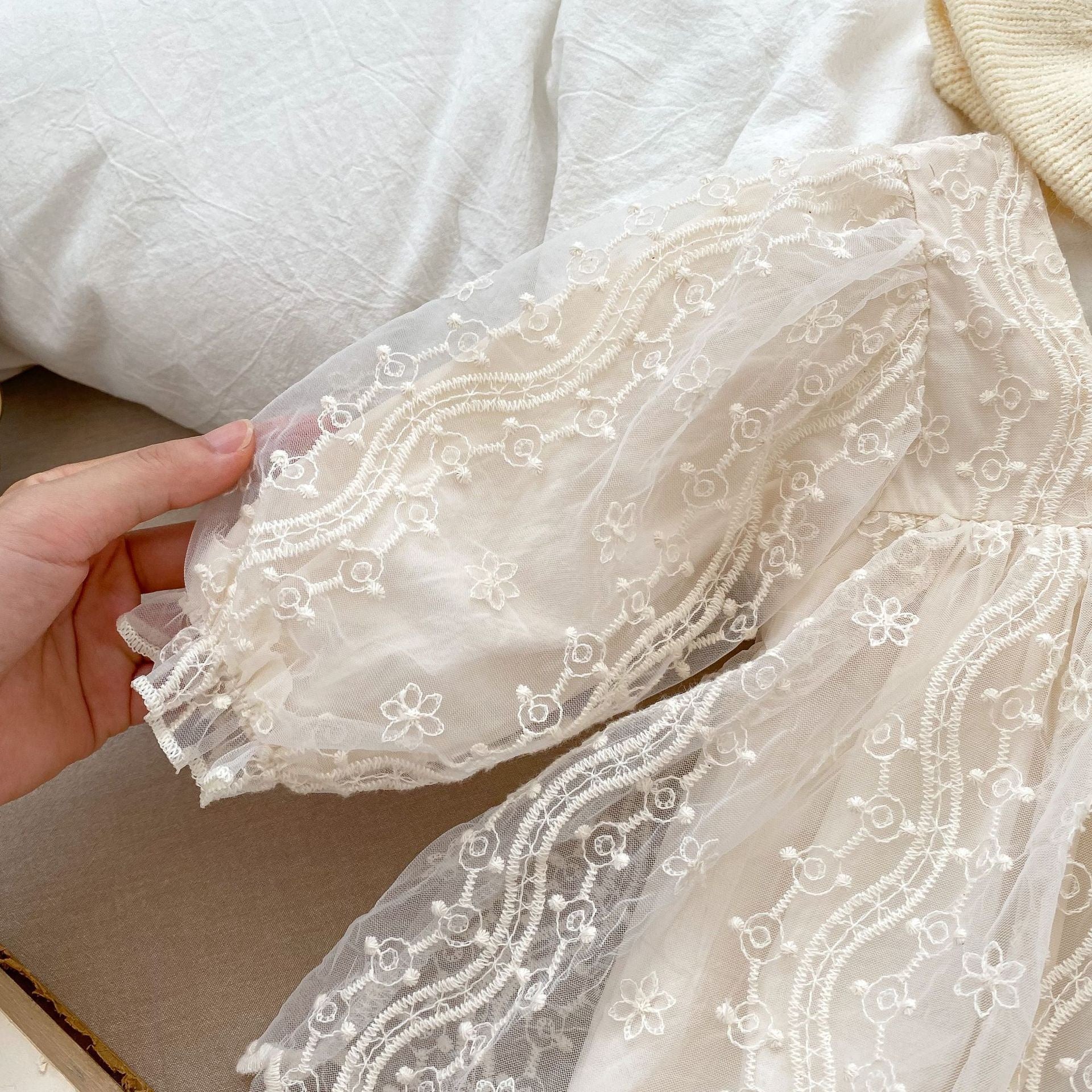 A stylish apricot onesies dress for baby girls featuring a mesh patched design, perfect for autumn wear.