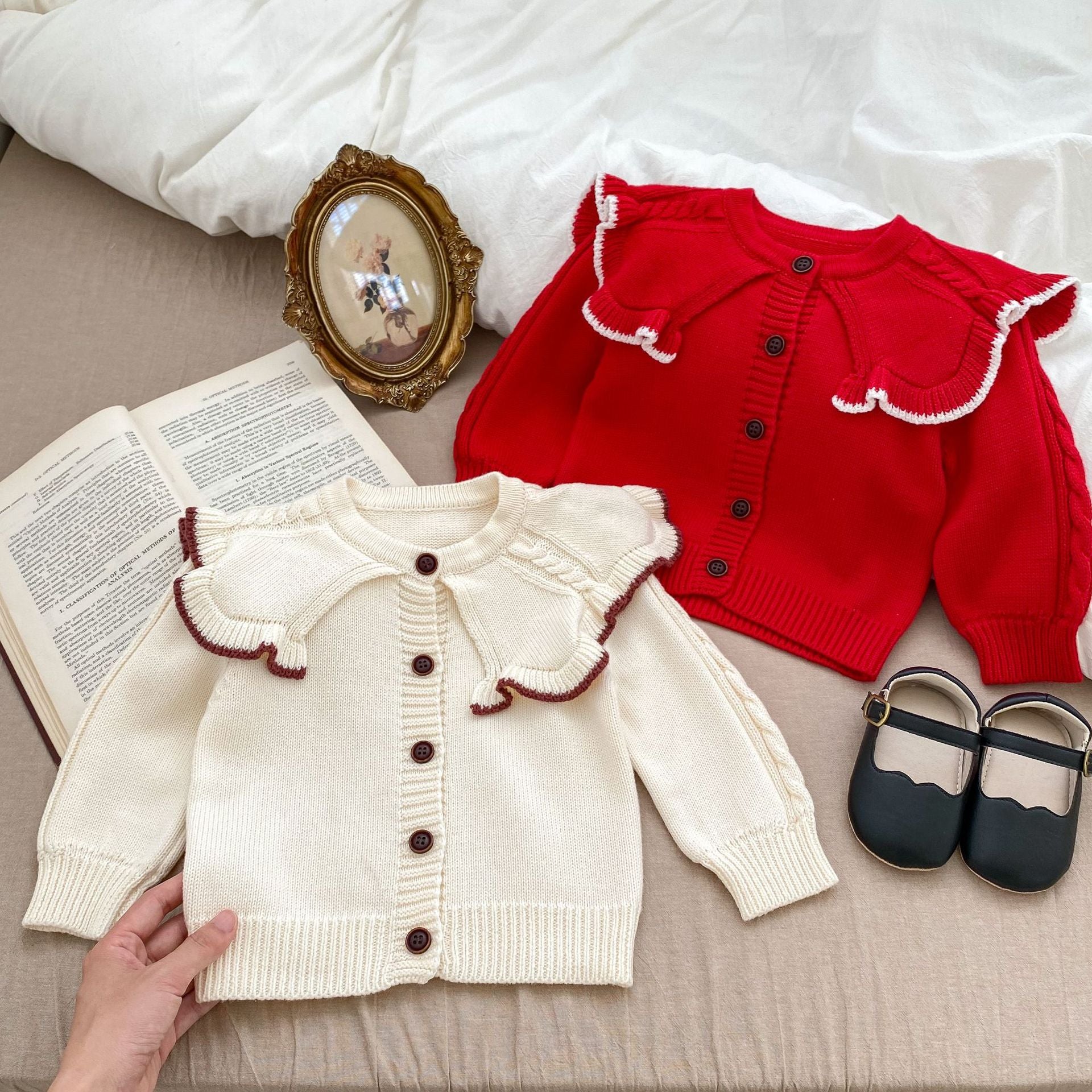 A cozy Autumn Vintage Style Knitted Cardigan for Baby Girl in red and beige, featuring floral and plain patterns, perfect for chilly weather.
