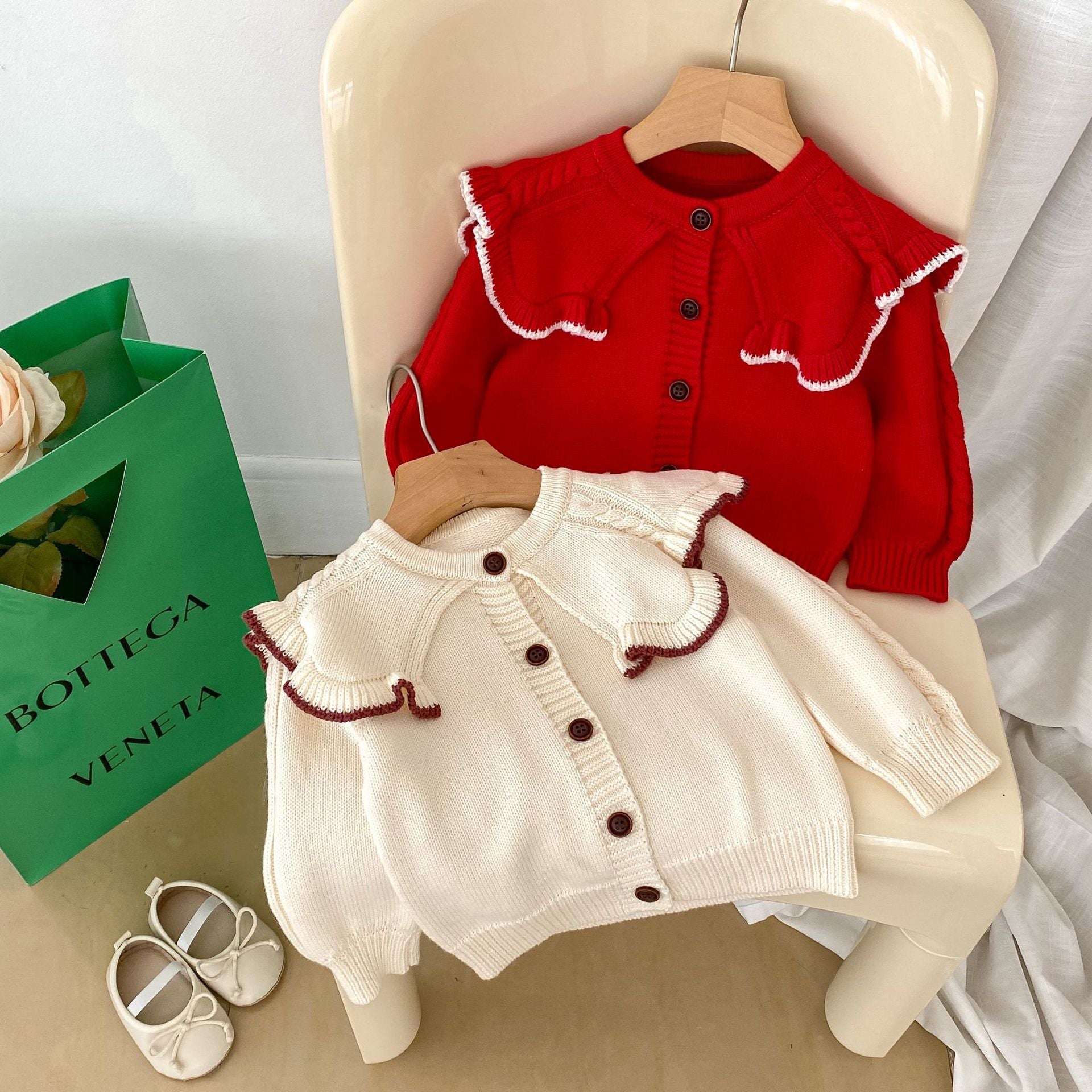 A cozy Autumn Vintage Style Knitted Cardigan for Baby Girl in red and beige, featuring floral and plain patterns, perfect for chilly weather.