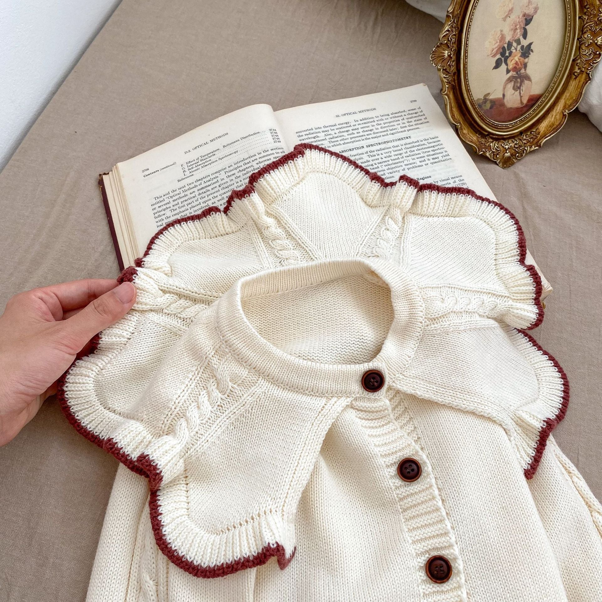 A cozy Autumn Vintage Style Knitted Cardigan for Baby Girl in red and beige, featuring floral and plain patterns, perfect for chilly weather.