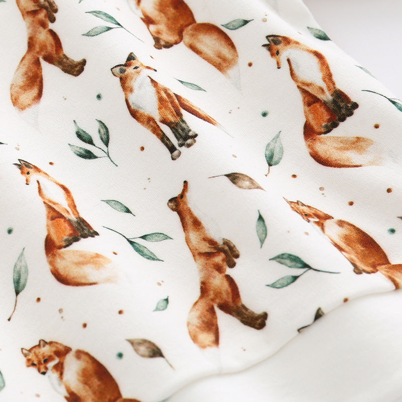 Baby wearing a brown organic cotton hoodie with an all-over fox graphic, showcasing comfort and style.