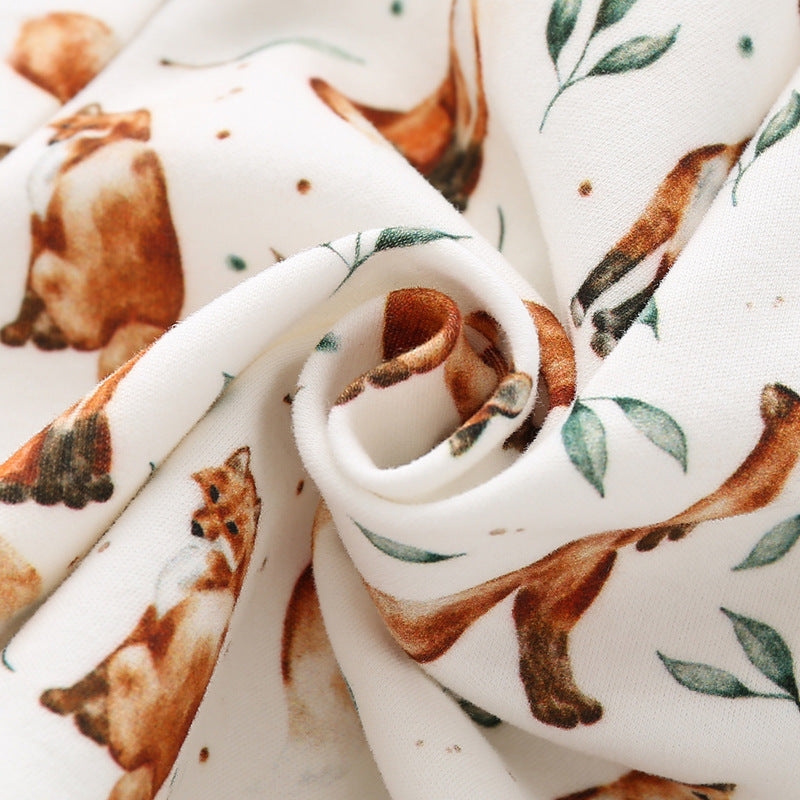 Baby wearing a brown organic cotton hoodie with an all-over fox graphic, showcasing comfort and style.