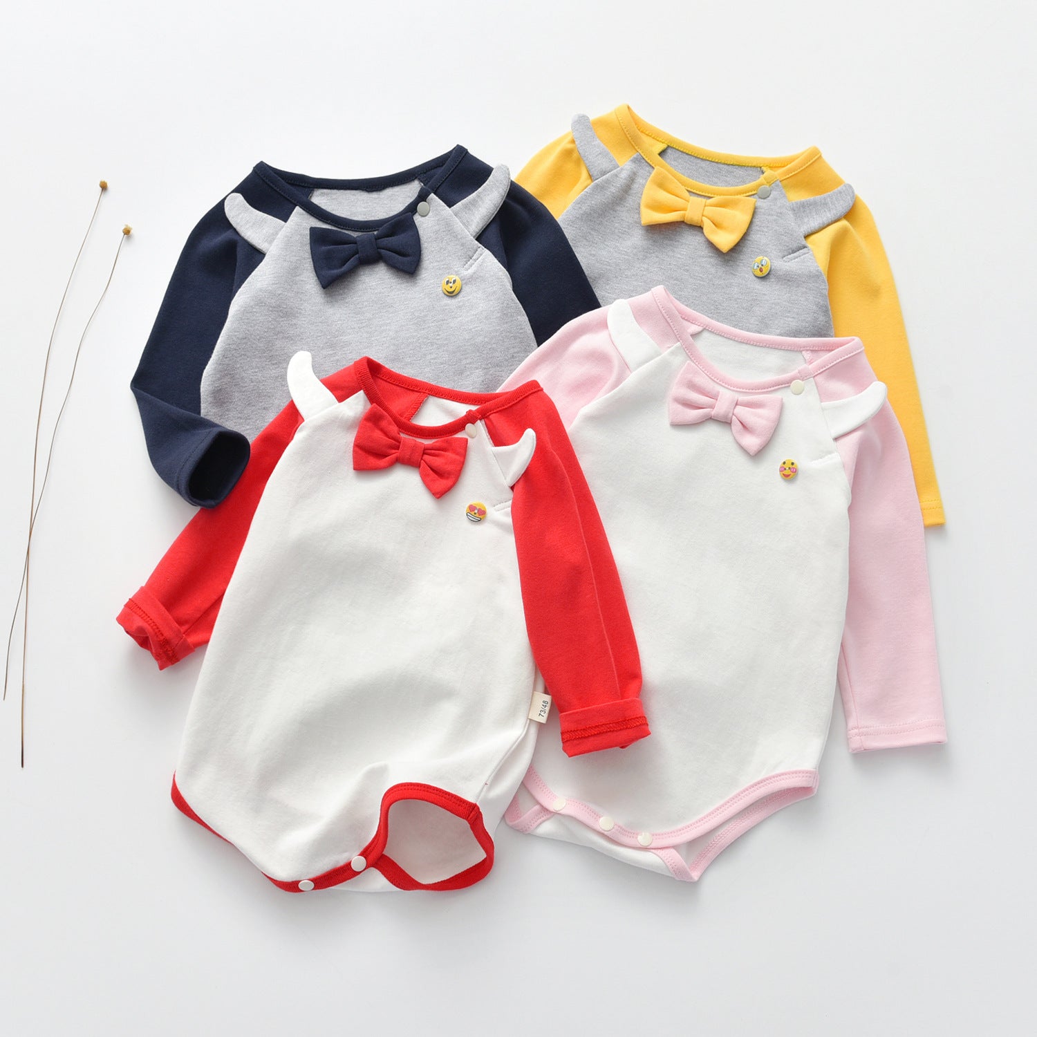 A stylish Baby Bow Tie Patched Onesie Bodysuit in vibrant colors, featuring a bow tie and patchwork design, perfect for special occasions.