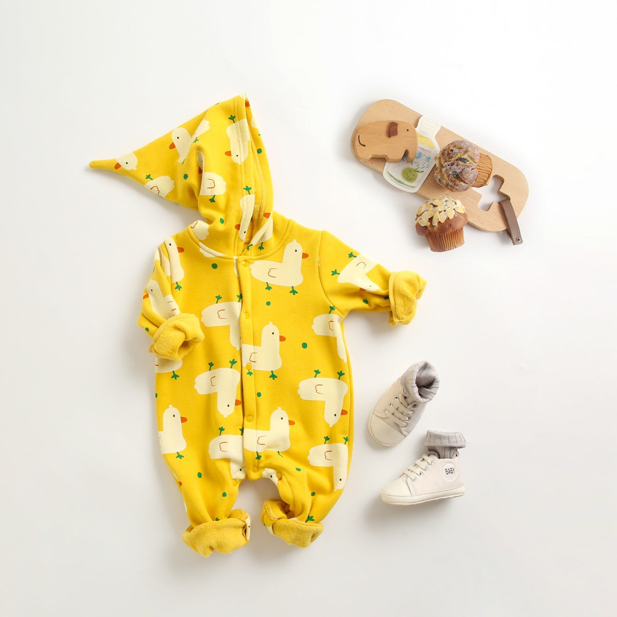 Baby wearing a cute cartoon duck print romper with matching hat, showcasing vibrant colors and playful design.