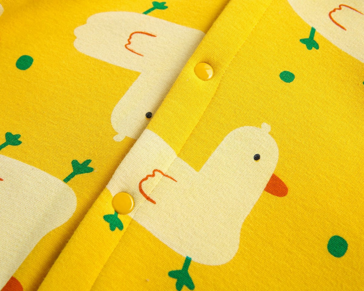 Baby wearing a cute cartoon duck print romper with matching hat, showcasing vibrant colors and playful design.