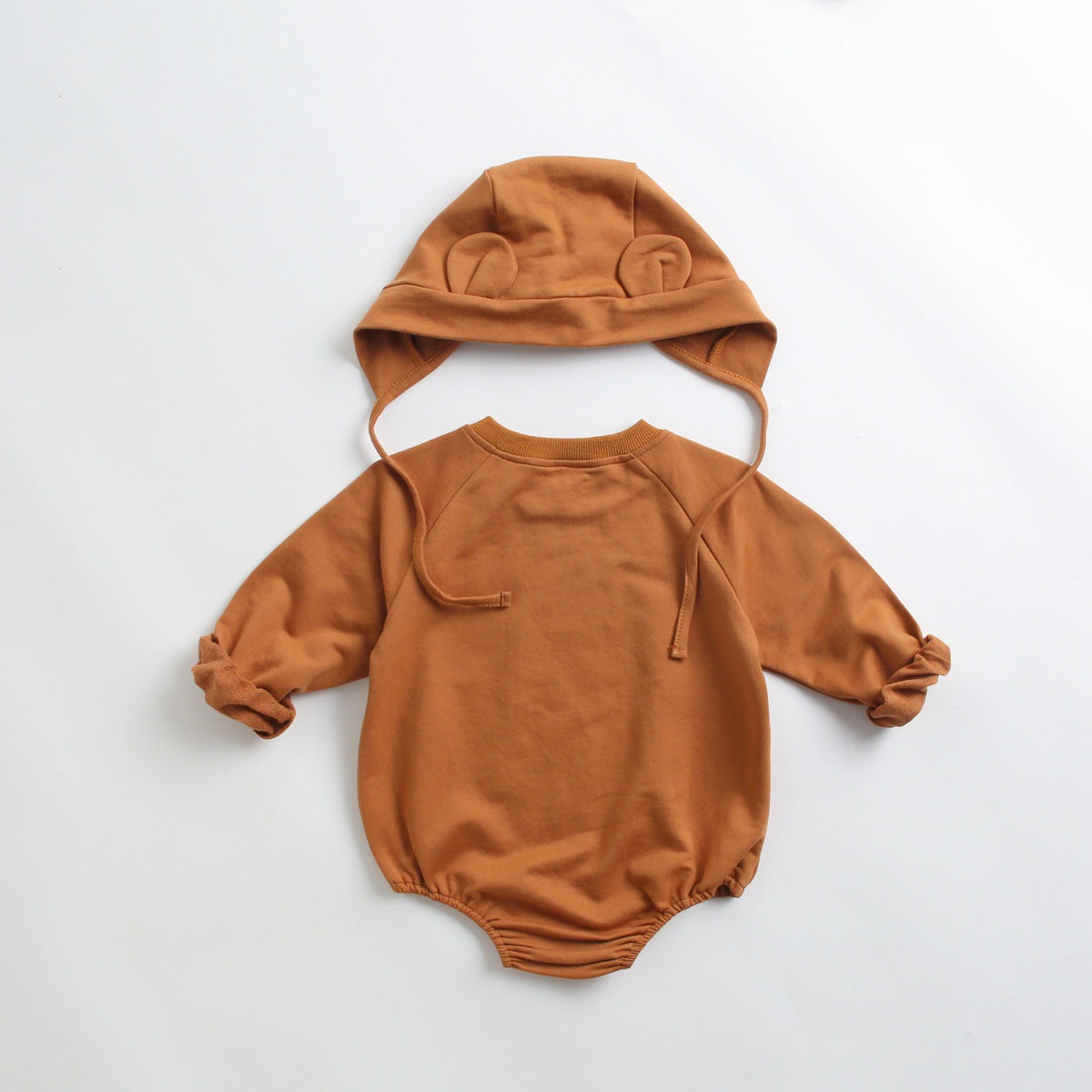 Baby wearing a long-sleeved cartoon print cotton onesie with a matching hat, showcasing a playful design in pink, grey, and brown colors.