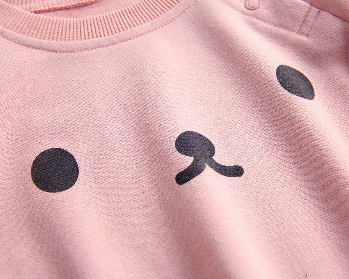 Baby wearing a long-sleeved cartoon print cotton onesie with a matching hat, showcasing a playful design in pink, grey, and brown colors.