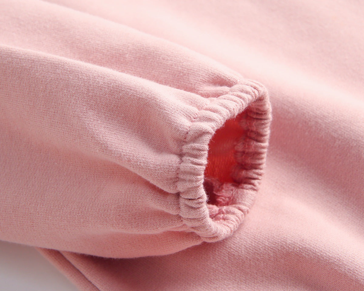 Baby wearing a long-sleeved cartoon print cotton onesie with a matching hat, showcasing a playful design in pink, grey, and brown colors.