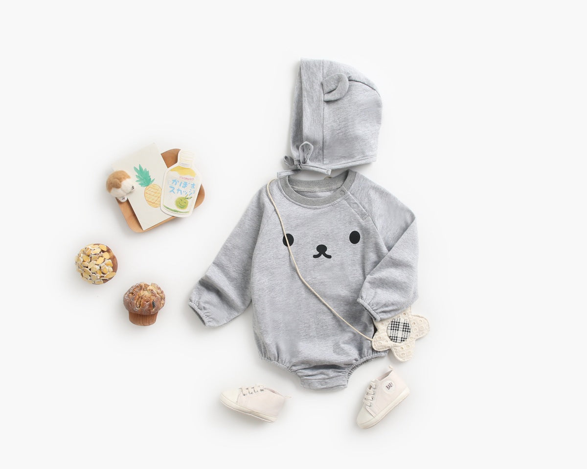Baby wearing a long-sleeved cartoon print cotton onesie with a matching hat, showcasing a playful design in pink, grey, and brown colors.