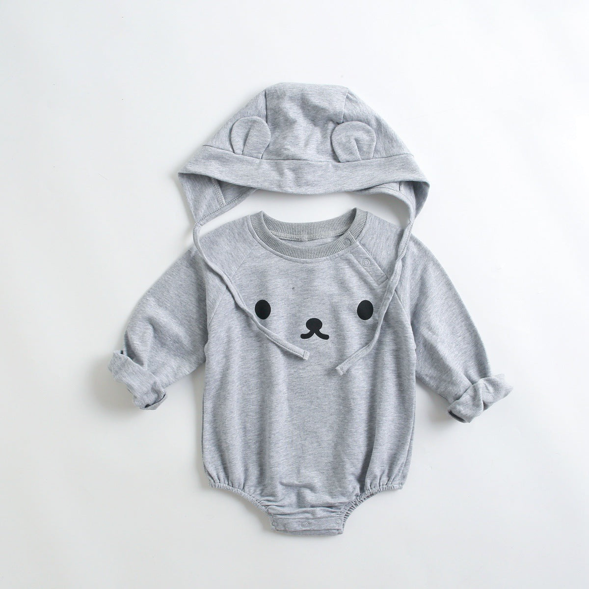 Baby wearing a long-sleeved cartoon print cotton onesie with a matching hat, showcasing a playful design in pink, grey, and brown colors.