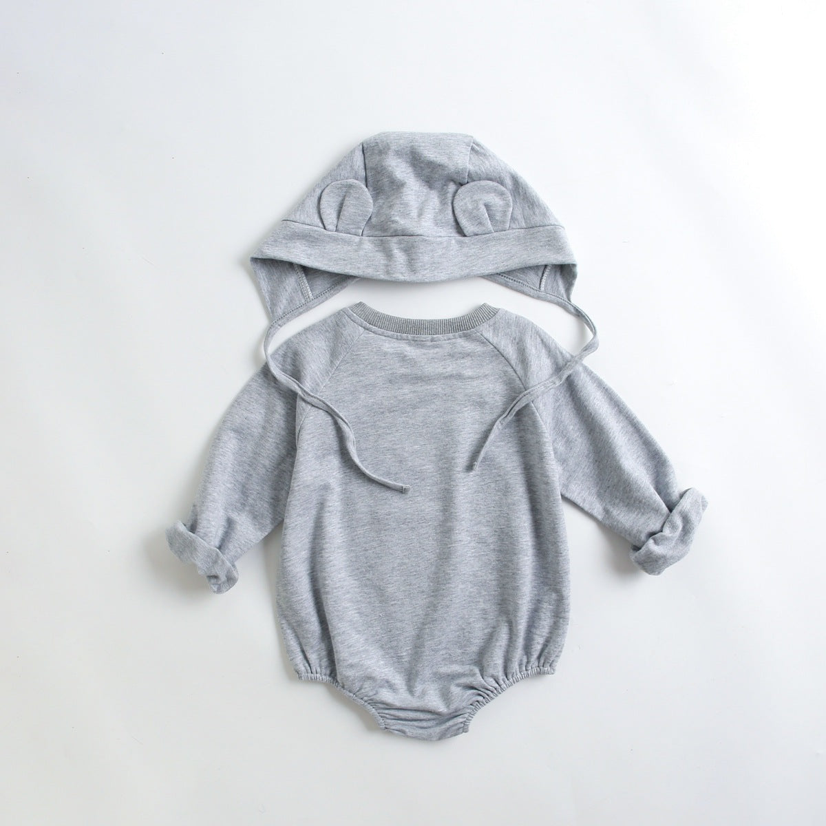 Baby wearing a long-sleeved cartoon print cotton onesie with a matching hat, showcasing a playful design in pink, grey, and brown colors.
