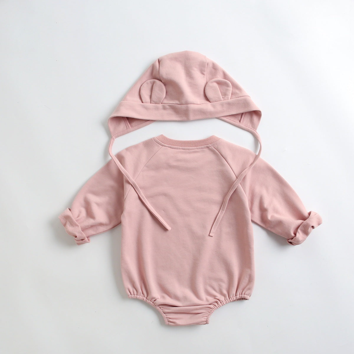 Baby wearing a long-sleeved cartoon print cotton onesie with a matching hat, showcasing a playful design in pink, grey, and brown colors.