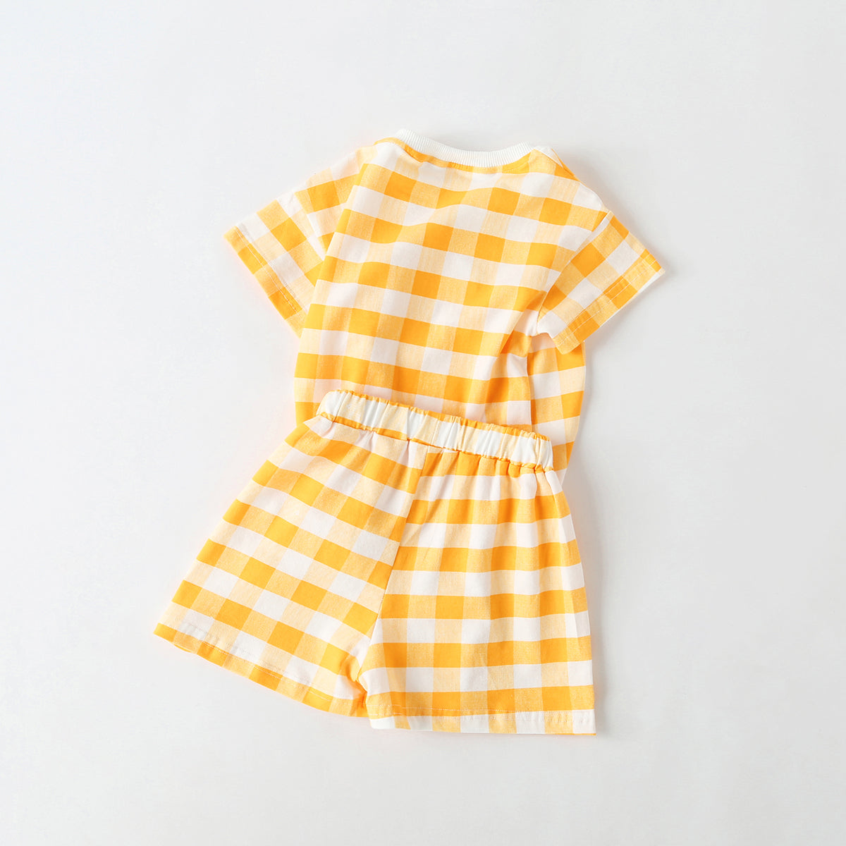Baby outfit featuring plaid and heart patterns in a tee and shorts set, available in white and yellow colors.