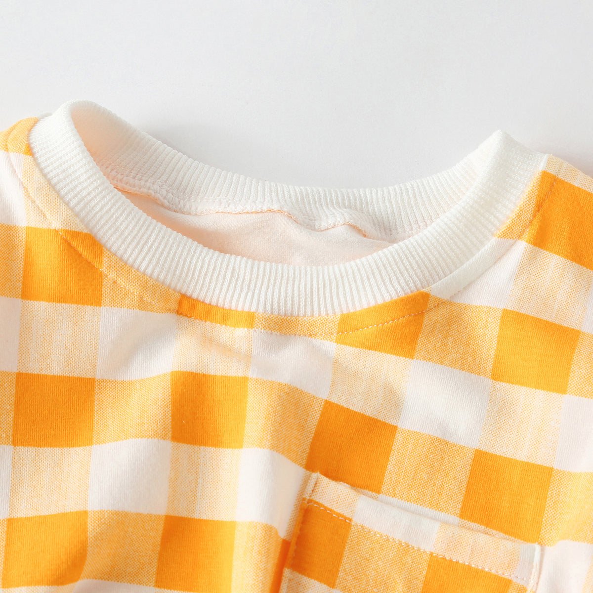 Baby outfit featuring plaid and heart patterns in a tee and shorts set, available in white and yellow colors.