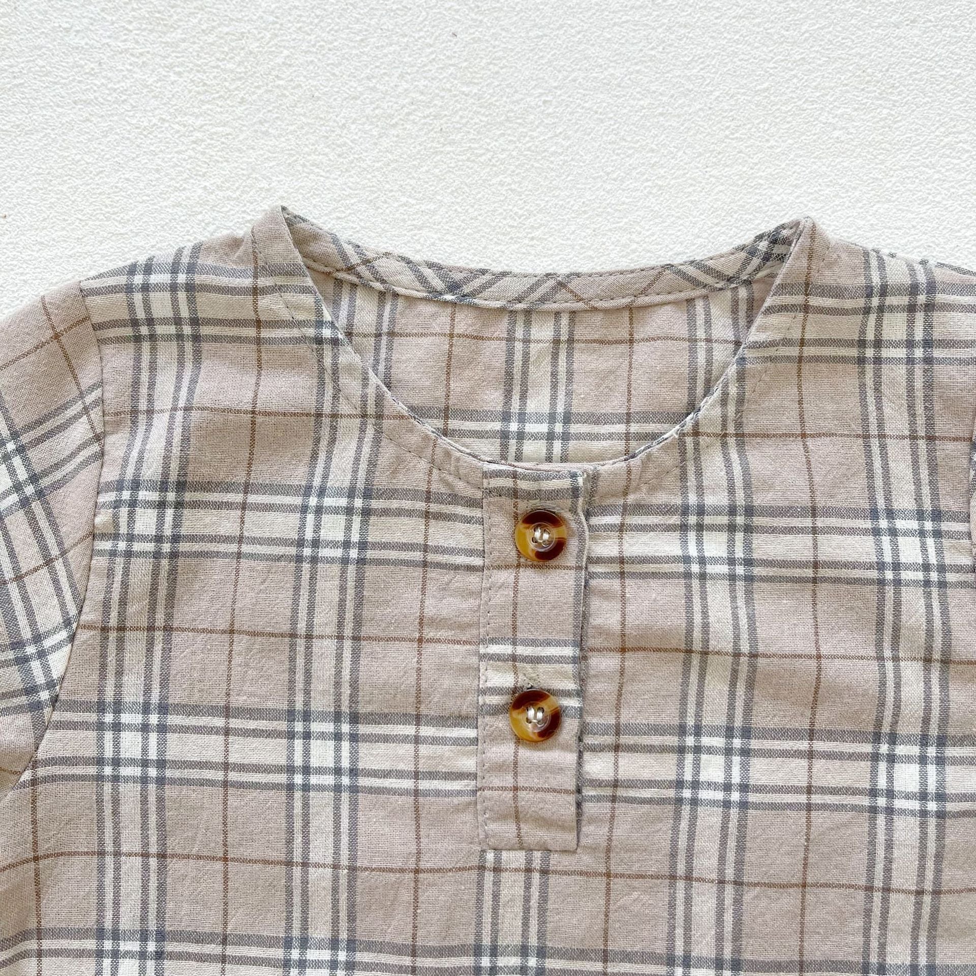 Baby boy and girl plaid pattern long-sleeved top combo with denim straps, showcasing a stylish and comfortable outfit for infants.