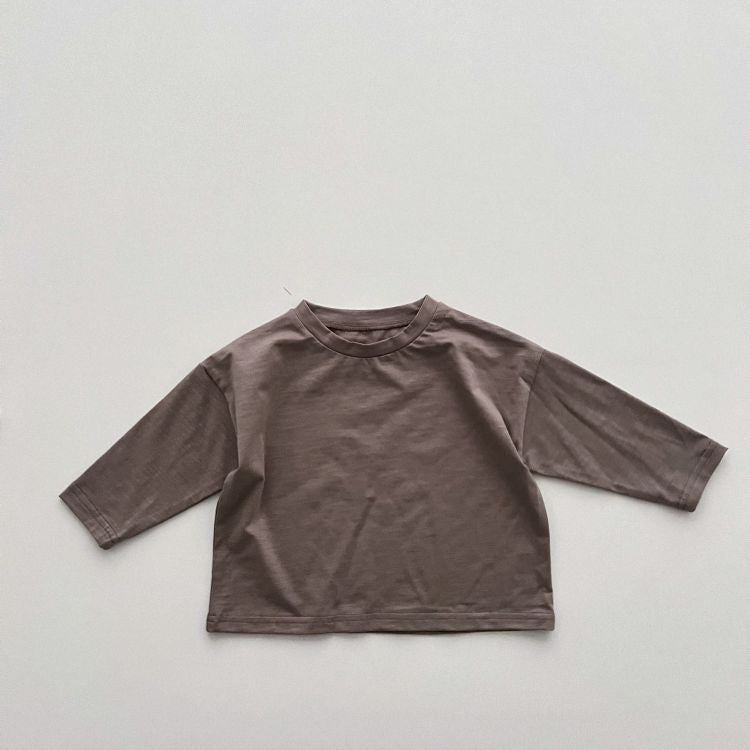 Baby boy and girl solid color pullover tops in white, black, and coffee, showcasing long sleeves and soft cotton fabric.