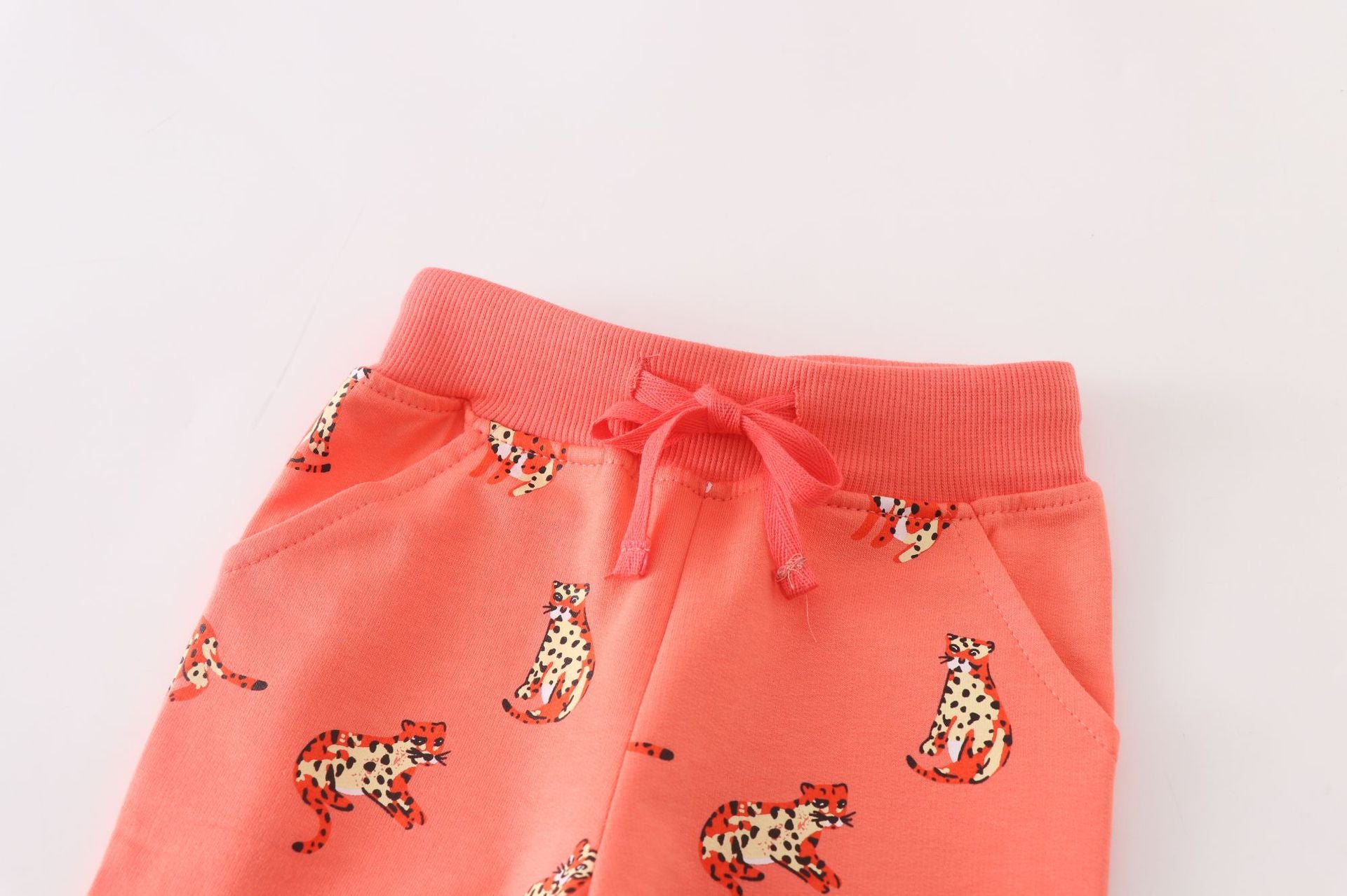 Baby boy soft cotton trousers featuring a cartoon animal pattern in vibrant orange color, perfect for playful days.
