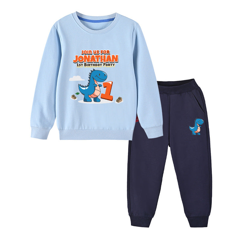 Baby boy wearing a cute cartoon dinosaur print hoodie and trousers set, showcasing vibrant colors and playful design.