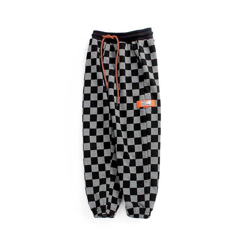 Baby boy wearing checkerboard print fleece thickened pants in black, showcasing warmth and style.