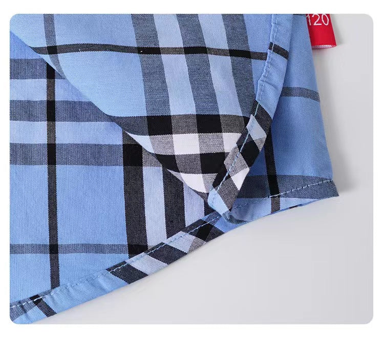 A stylish baby boy wearing a classic plaid pattern button front lapel shirt in red, green, and beige colors.