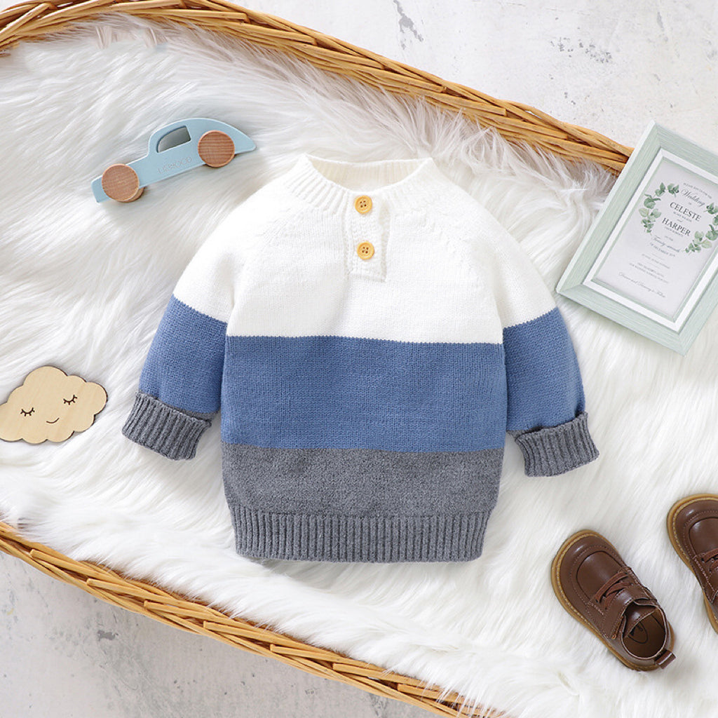 Baby boy wearing a stylish color block pullover with quarter-button design in blue and green, perfect for spring and autumn.