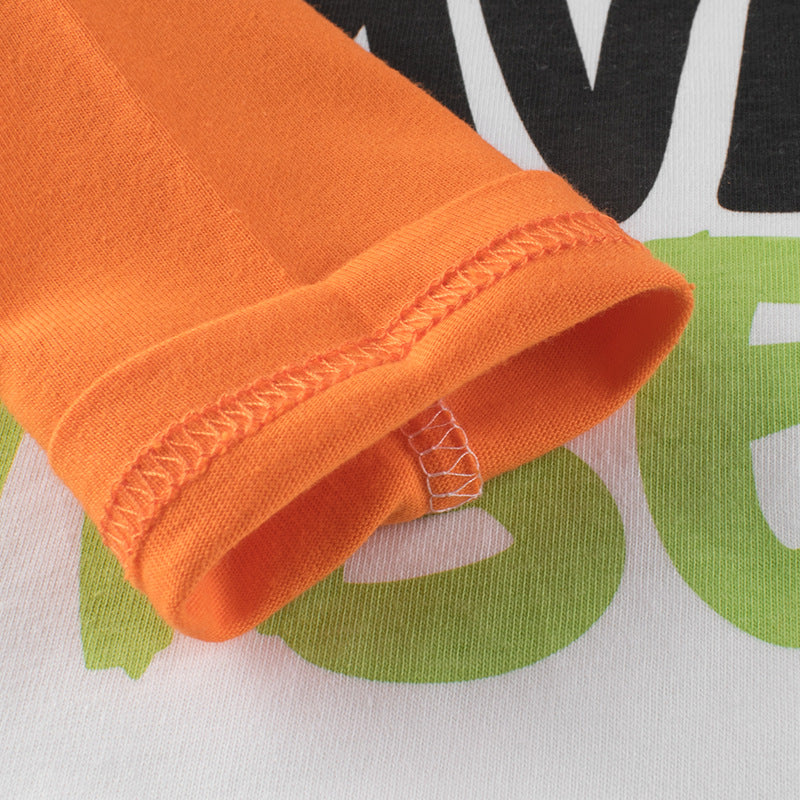 A colorful long-sleeved shirt for baby boys featuring a vibrant blue and orange design with slogan prints and patchwork details.