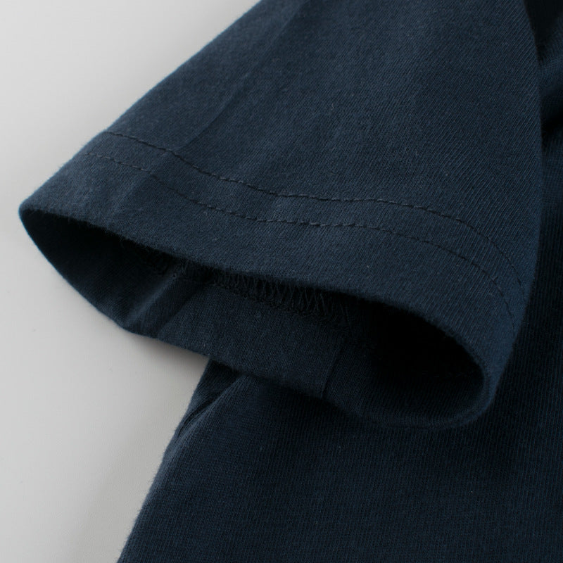 Baby boy wearing a dinosaur print round collar short-sleeved tee shirt in black, perfect for summer.