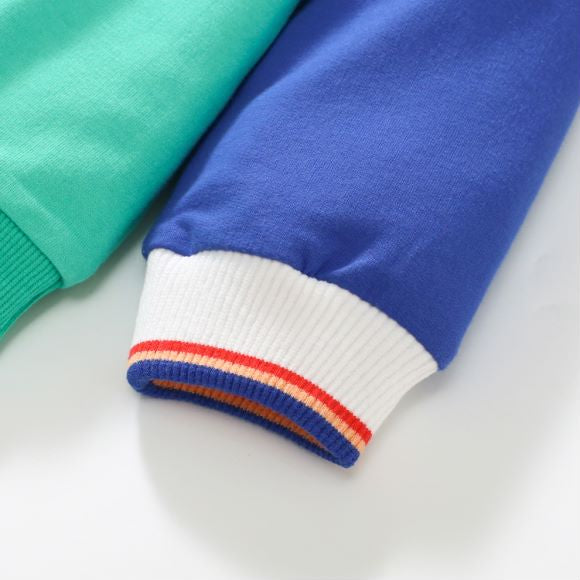 Baby boy wearing a blue hoodie with letter pattern and patchwork design, showcasing comfort and style.