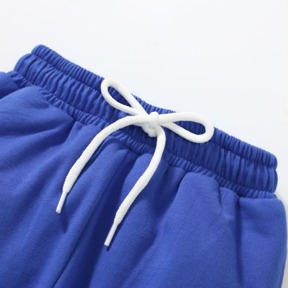 Baby boy wearing a blue hoodie with letter pattern and patchwork design, showcasing comfort and style.