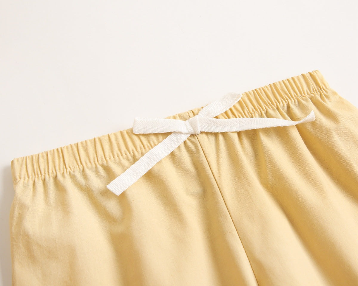 Baby boy wearing a stylish plaid pattern polo-neck shirt and shorts combo in vibrant colors.