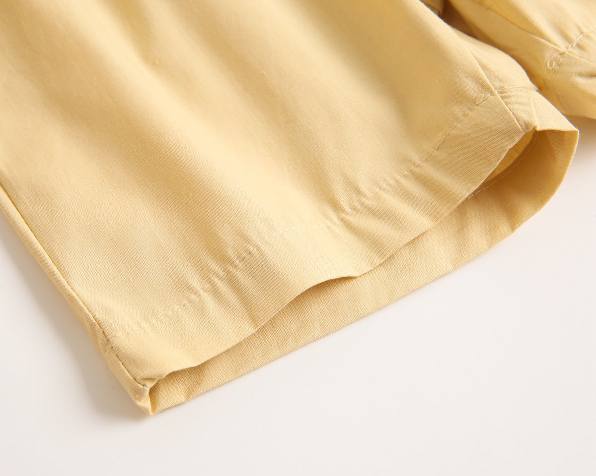 Baby boy wearing a stylish plaid pattern polo-neck shirt and shorts combo in vibrant colors.