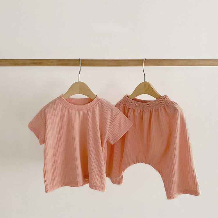 Baby boys and girls solid color round neck short-sleeved top combo in black, pink, green, and apricot, made of 100% cotton for comfort.