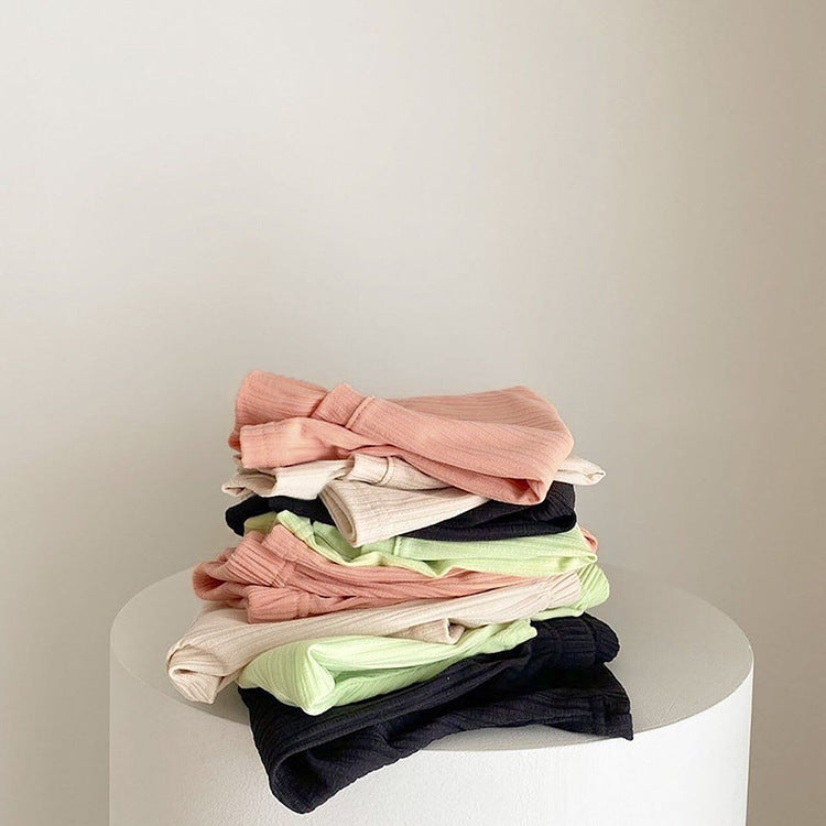 Baby boys and girls solid color round neck short-sleeved top combo in black, pink, green, and apricot, made of 100% cotton for comfort.