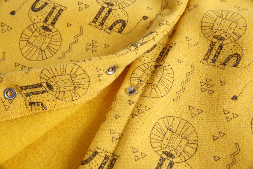 Baby wearing a cute cartoon animal romper with a matching hat, showcasing a playful design in yellow and khaki colors.