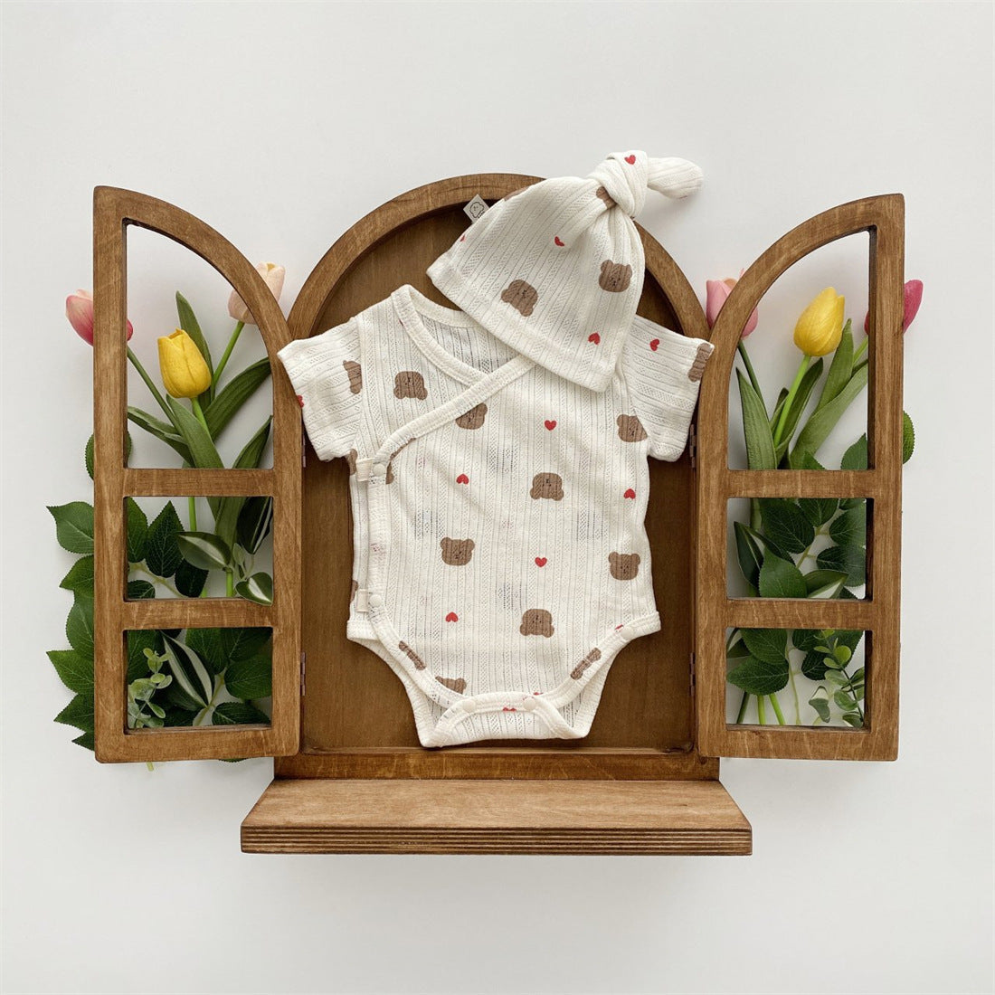 Baby girl wearing a soft cotton onesie with cartoon animal graphics in a vibrant color.