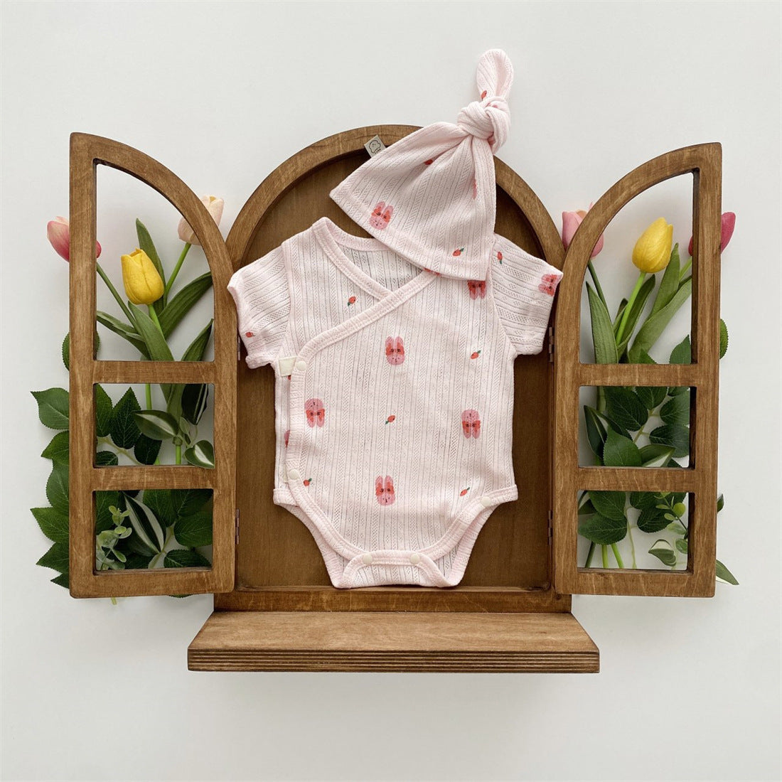 Baby girl wearing a soft cotton onesie with cartoon animal graphics in a vibrant color.