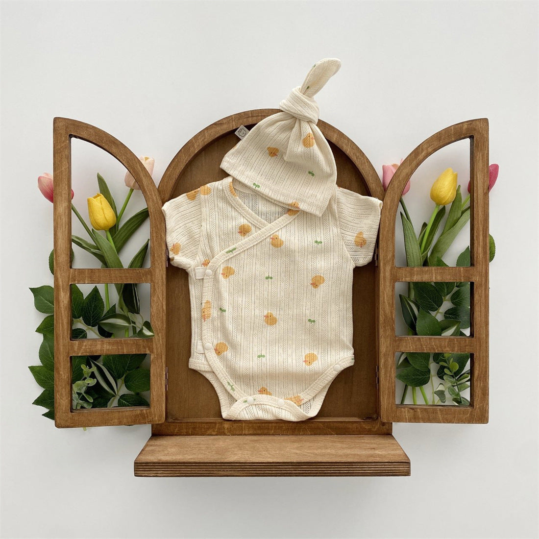 Baby girl wearing a soft cotton onesie with cartoon animal graphics in a vibrant color.