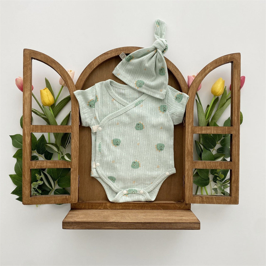 Baby girl wearing a soft cotton onesie with cartoon animal graphics in a vibrant color.