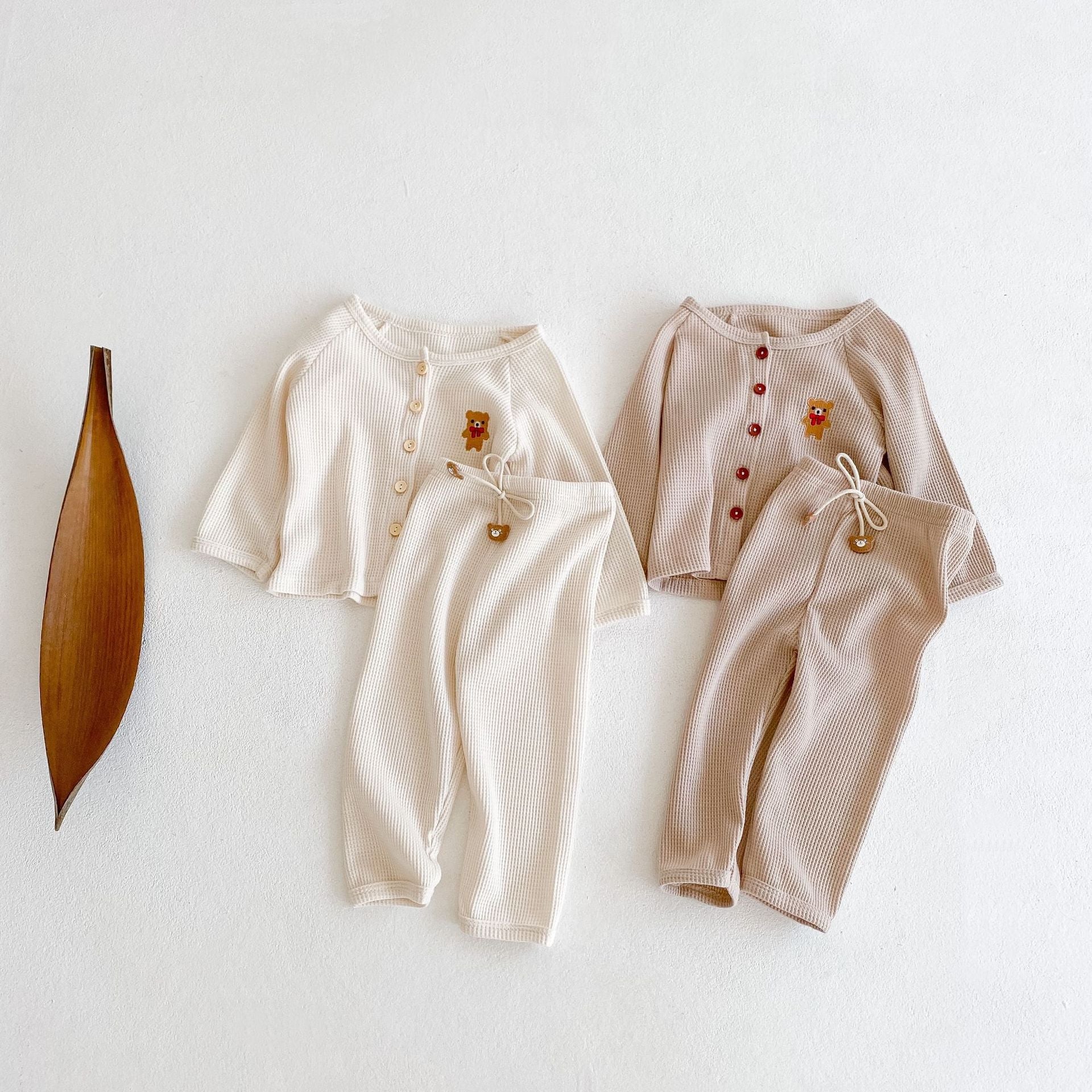 Baby outfit featuring a cartoon bear embroidery, waffle knitted cardigan, and combo pants in khaki and apricot colors.