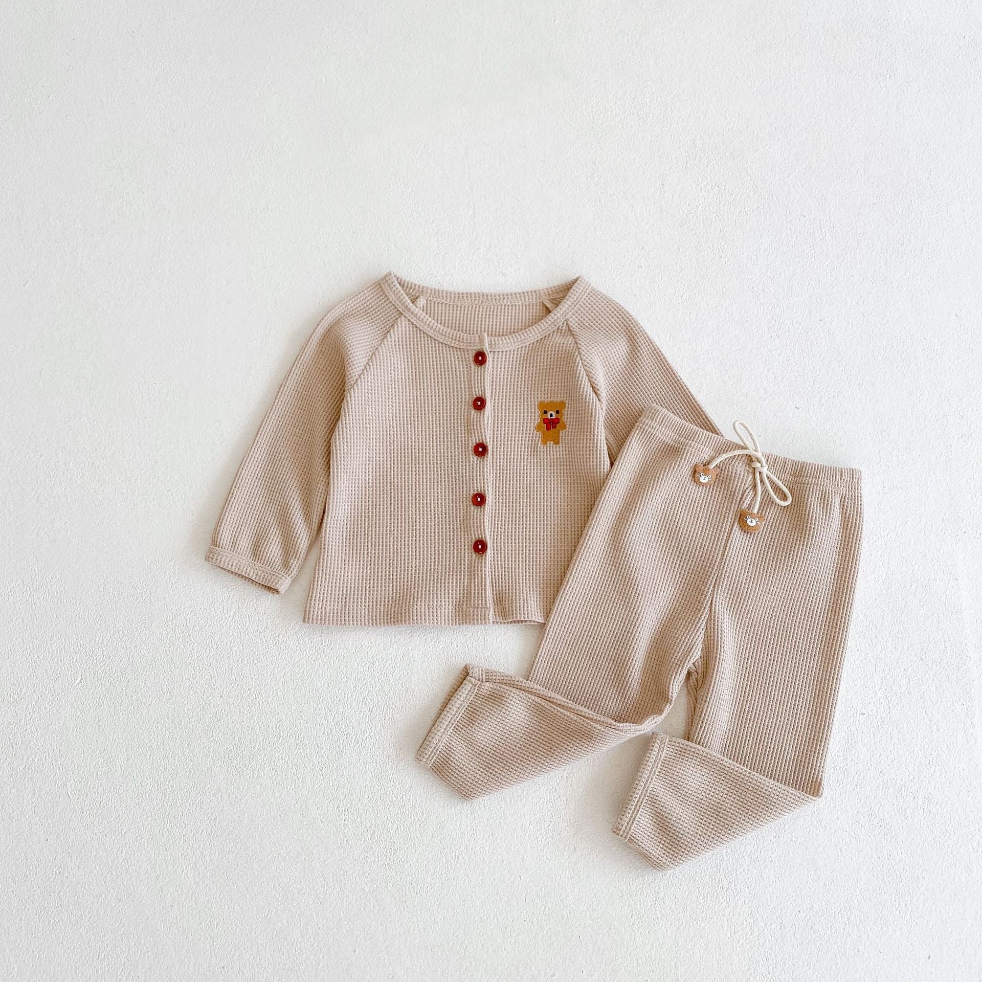 Baby outfit featuring a cartoon bear embroidery, waffle knitted cardigan, and combo pants in khaki and apricot colors.