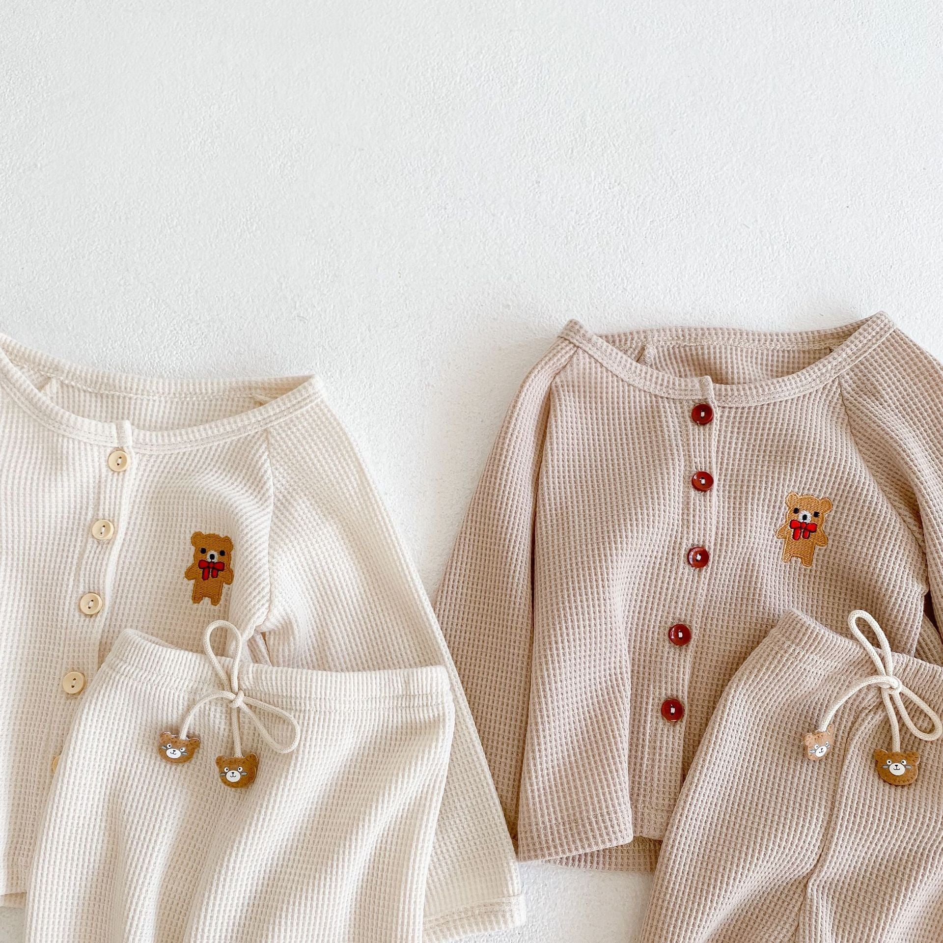 Baby outfit featuring a cartoon bear embroidery, waffle knitted cardigan, and combo pants in khaki and apricot colors.